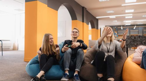 A cheerful team Play video games on the console while relaxing on beanbags after work
